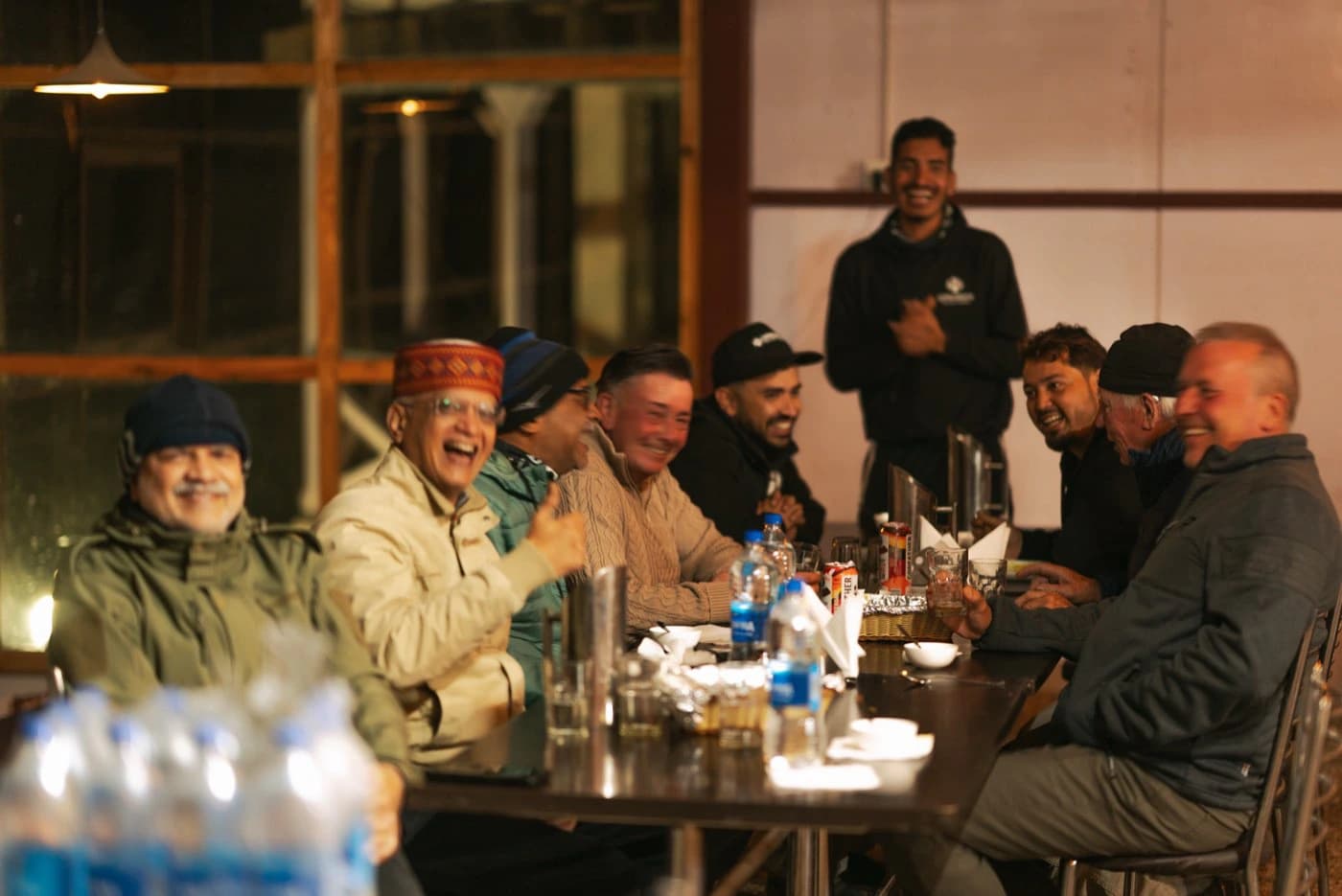 Riders and crew laughing over dinner at the hotel in Padum at the end of Day 4