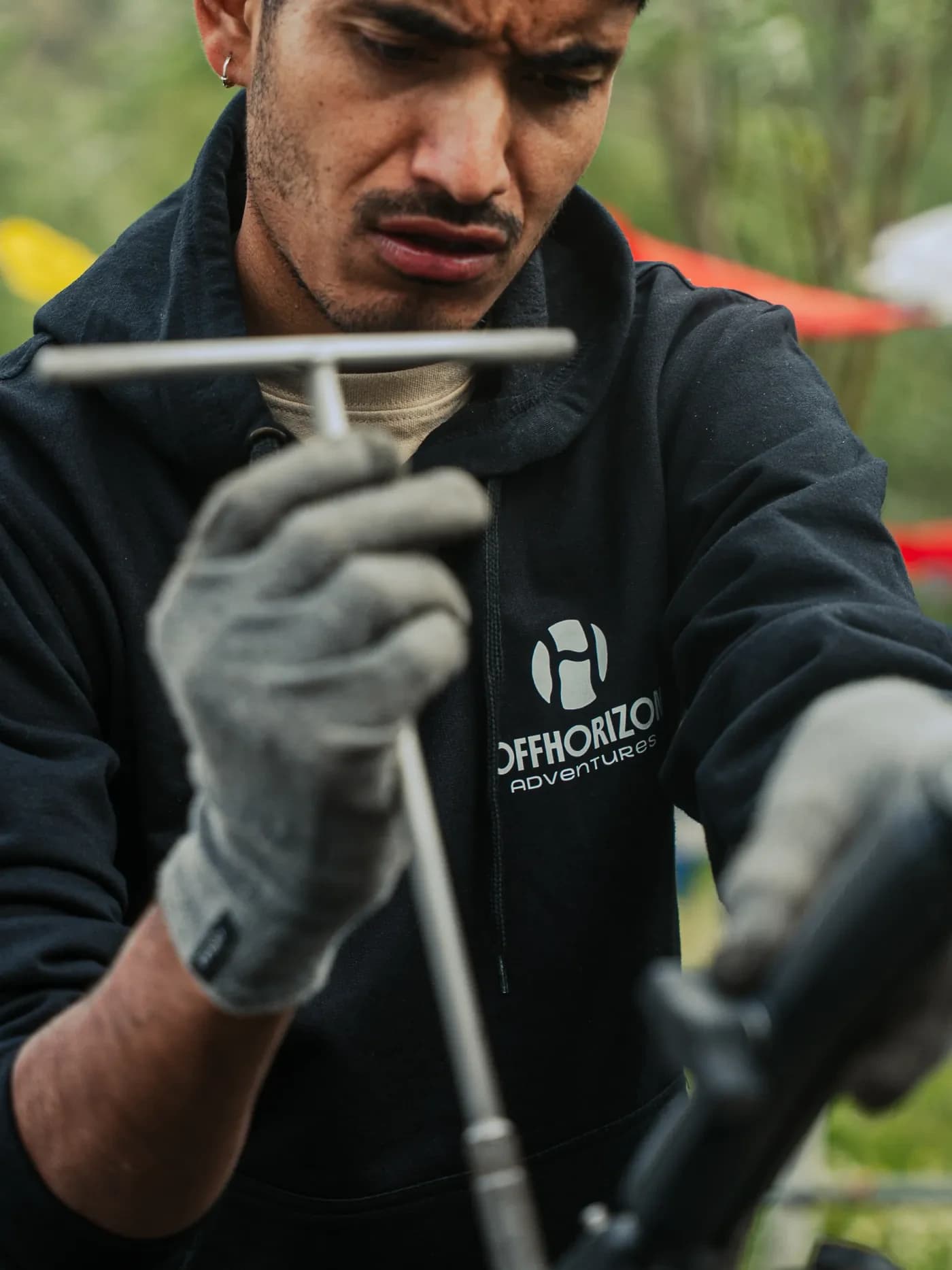 Mechanic in gloves using a T-handle tool on a motorcycle