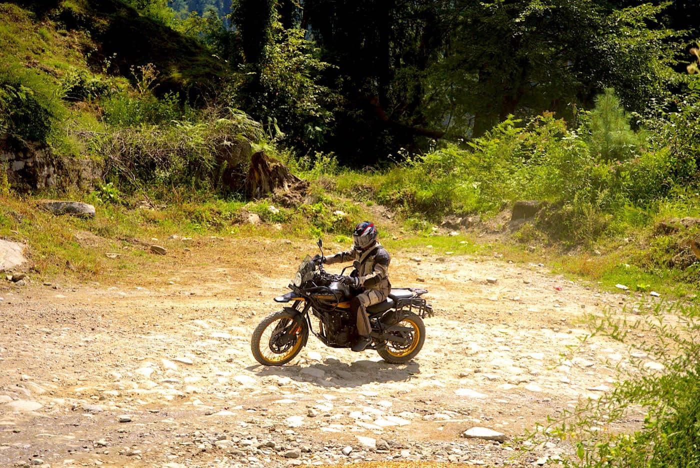 Motorcyclist taking a loose gravel hairpin bend on the Hamta road near Manali