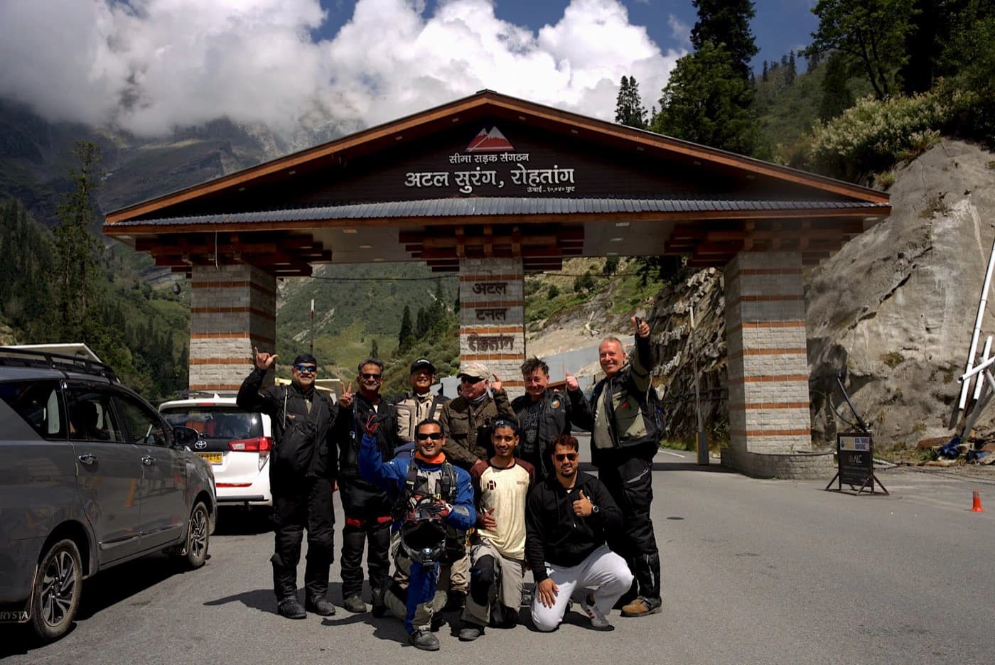 Riders and crew at the south portal gate of the Atal Tunnel near Manali