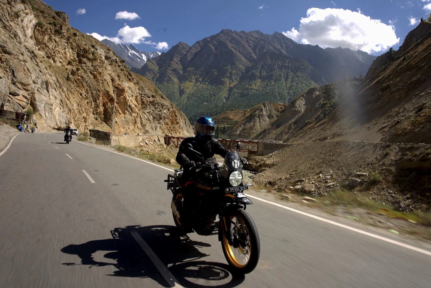 Rider on a Royal Enfield Himalayan 450 in a narrow rocky gorge on the road from Keylong to Jispa