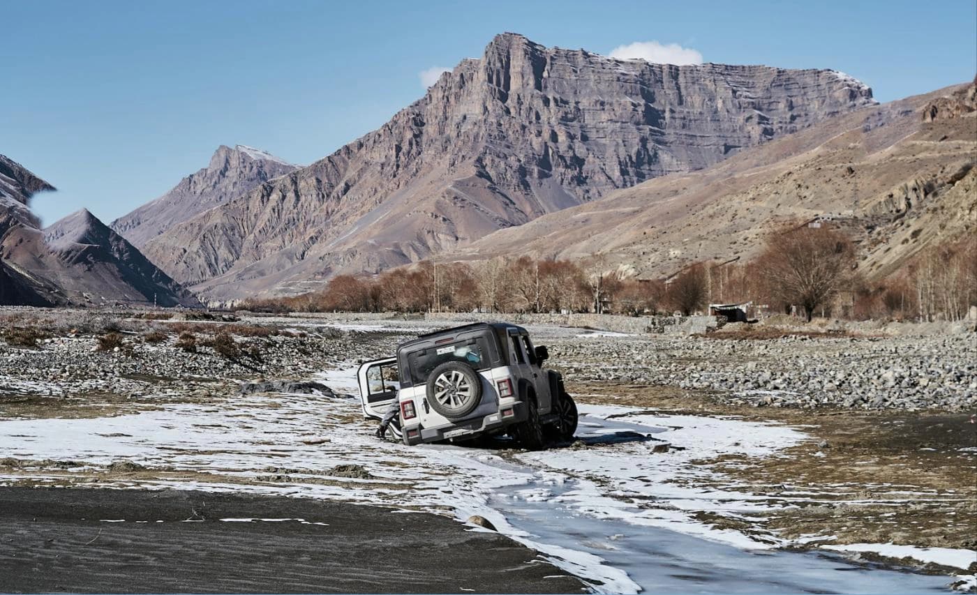 4x4 crossing a frozen stream bed in Spiti Valley in winter