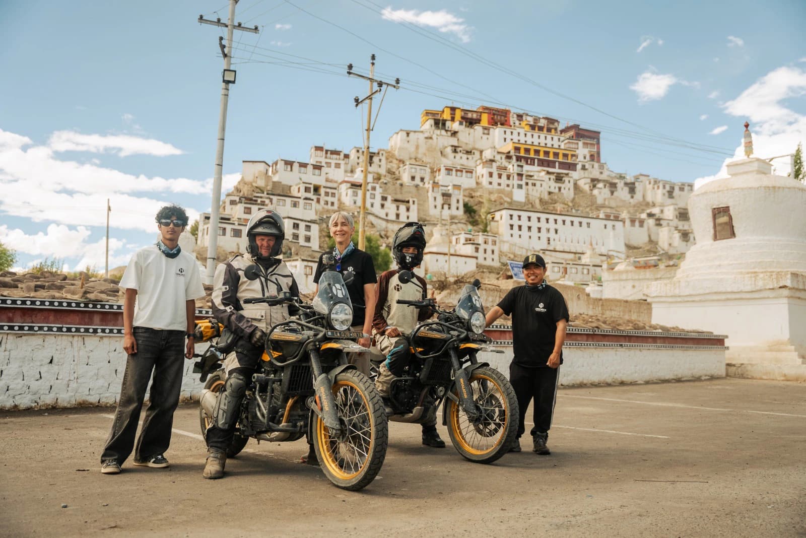 Motorcycle tour group with Royal Enfield Himalayan 450s in front of Thiksey Monastery near Leh