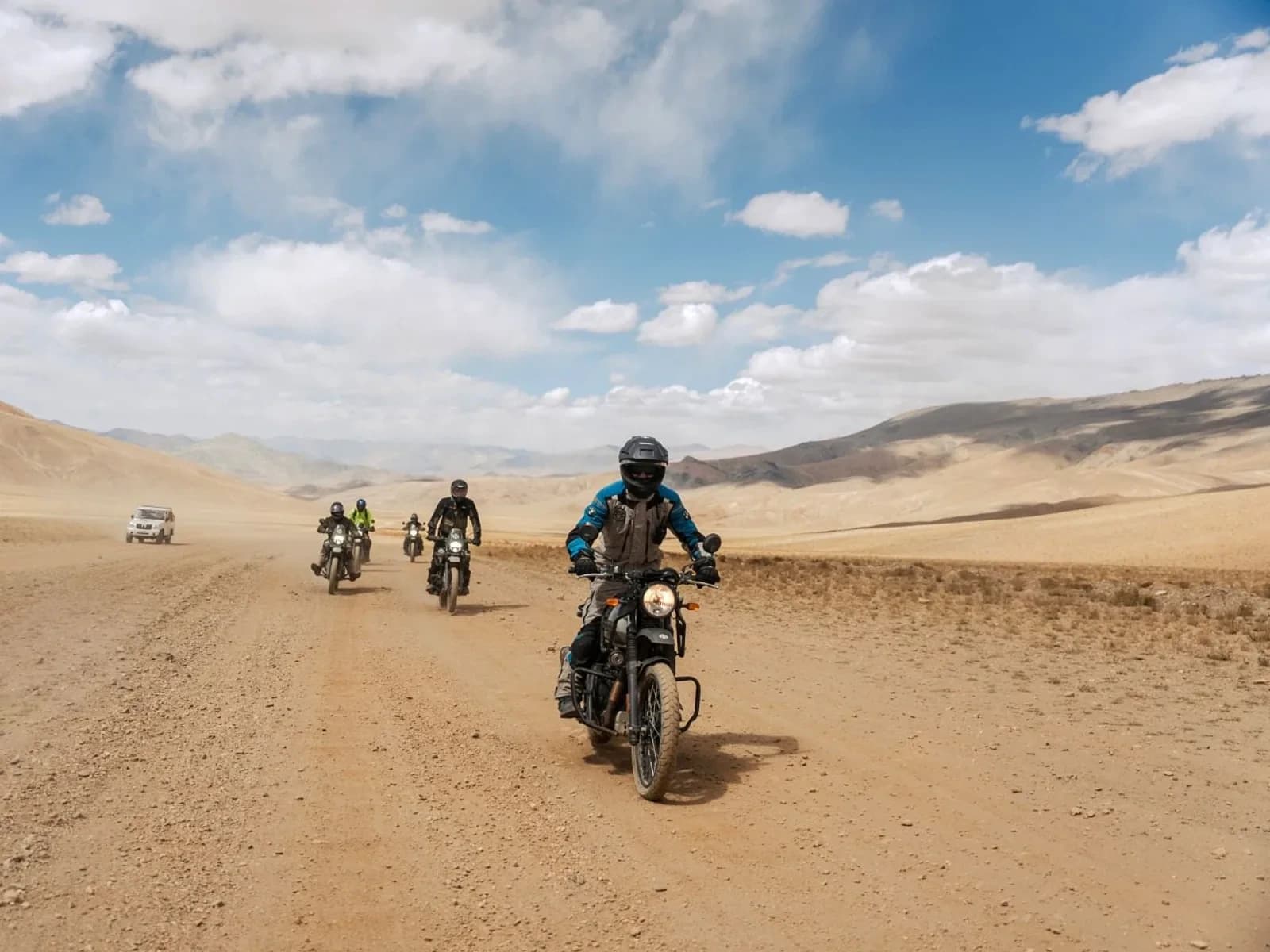 Riders crossing a wide high-altitude plain in Ladakh