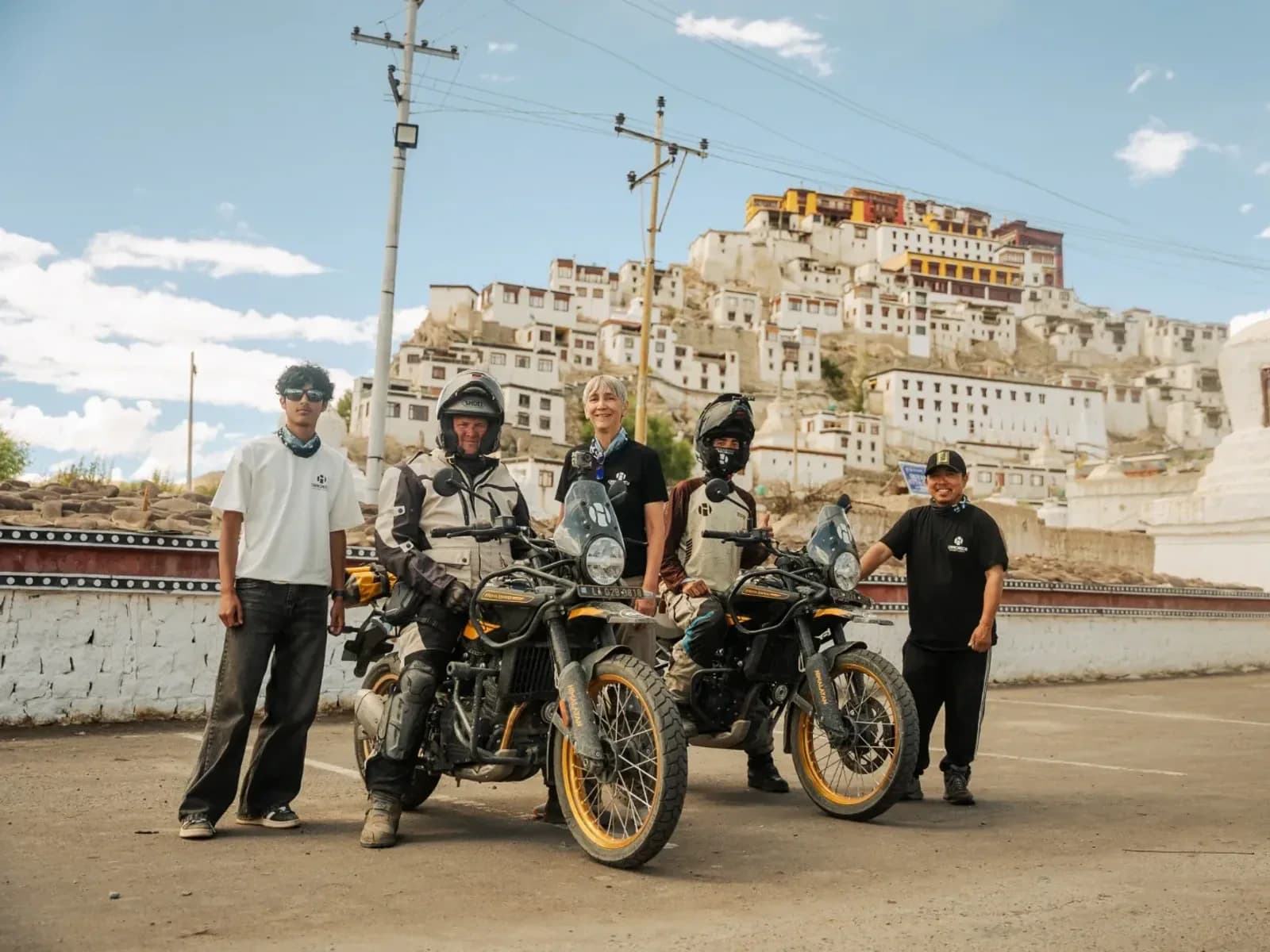 Motorcycle tour group with Royal Enfield Himalayan 450s in front of Thiksey Monastery near Leh