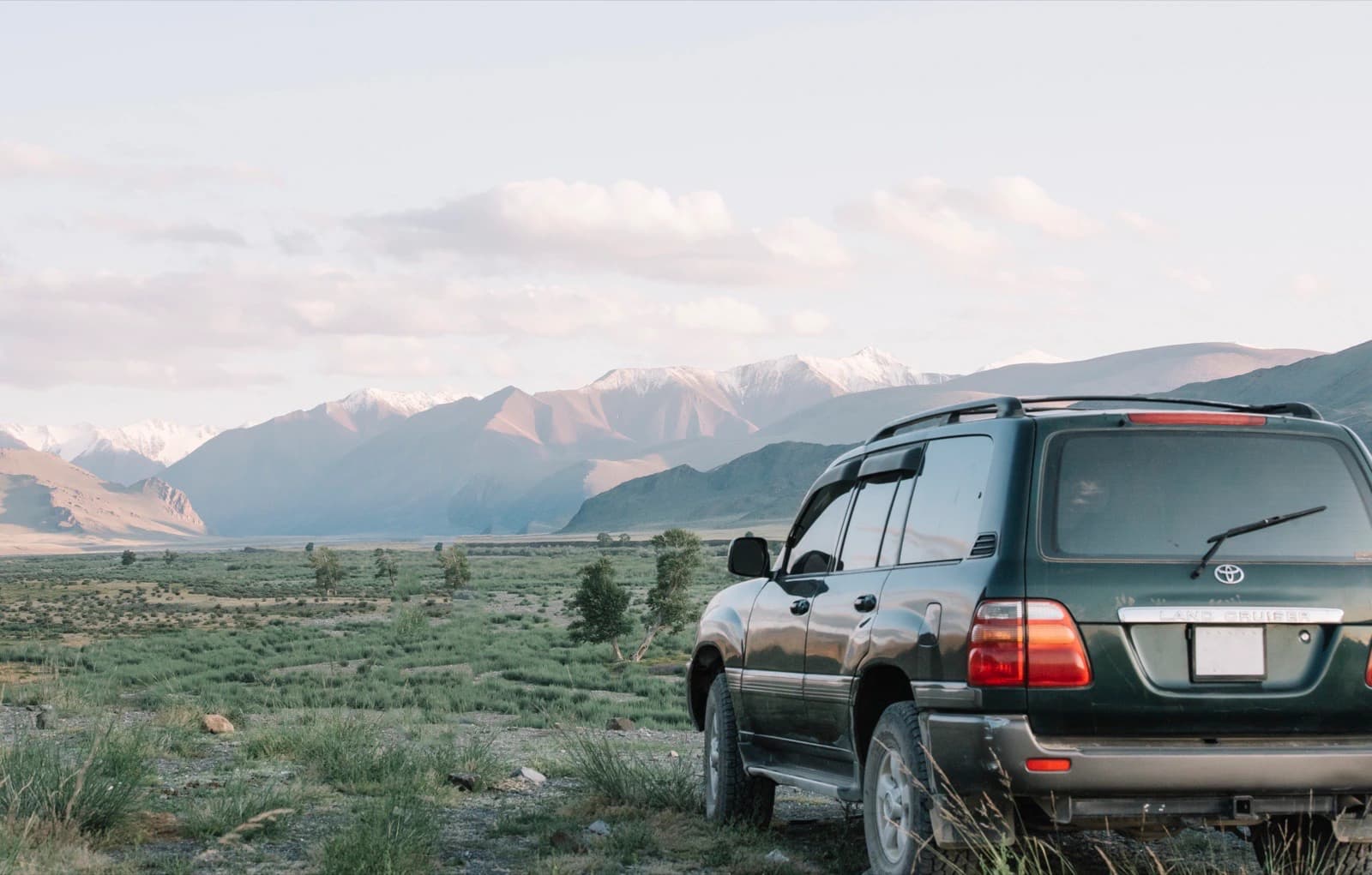 Toyota Land Cruiser facing snow-capped mountains on a Mongolia 4x4 tour
