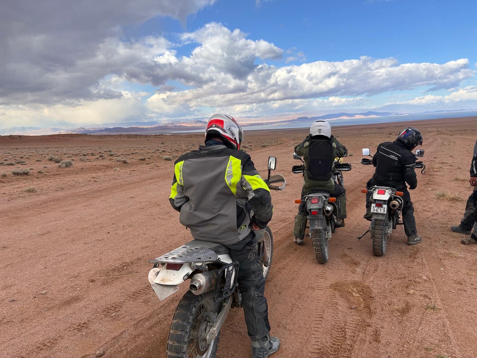 Three riders stopped on a sandy track in Mongolia