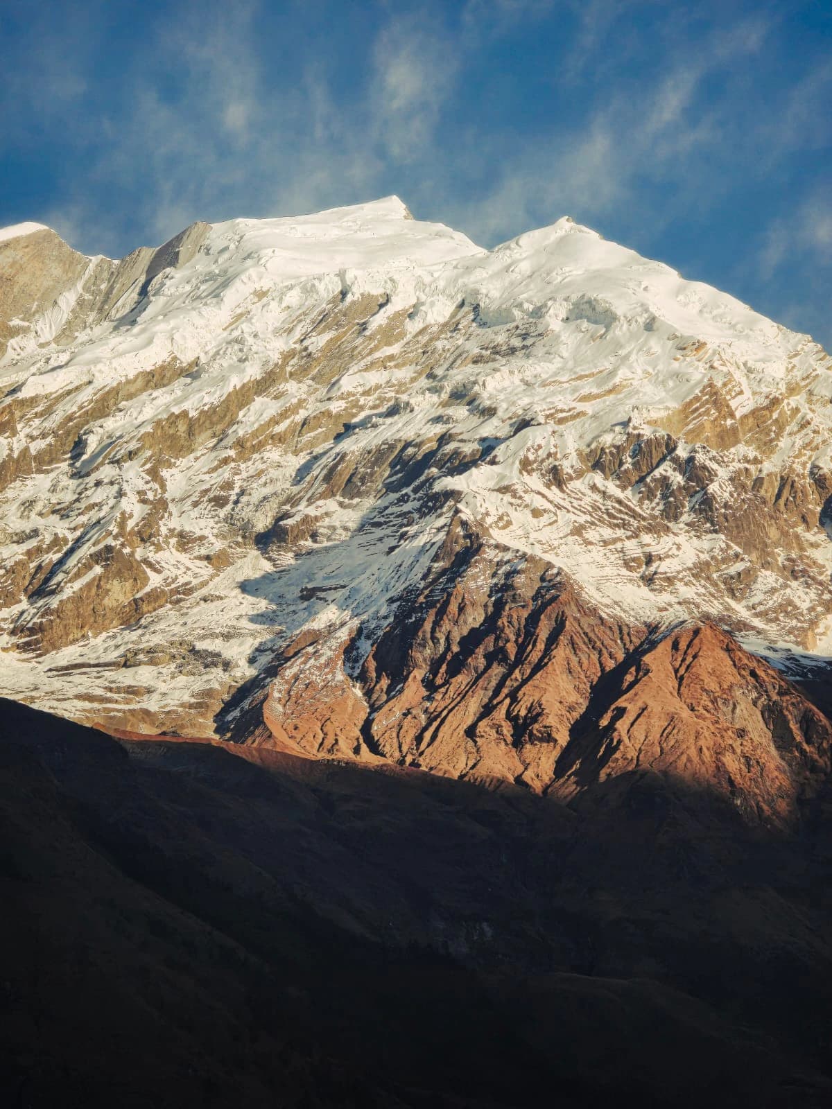 Majestic 8000-meter Himalayan peak in Nepal covered with snow and glaciers beneath a clear blue sky.