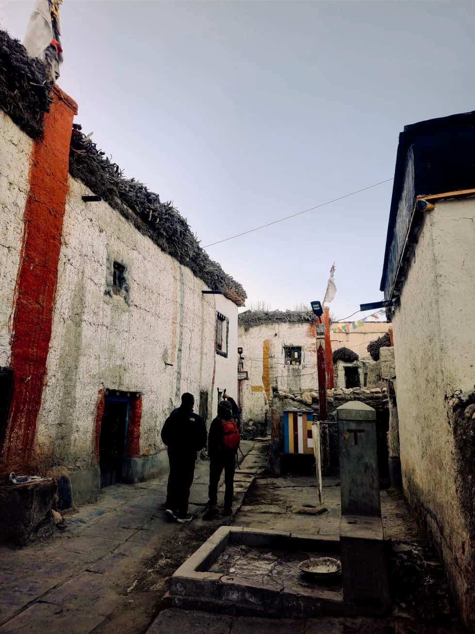 Traditional whitewashed village houses and narrow stone alley in Lo Manthang, the Forbidden Kingdom of Upper Mustang, Nepal.