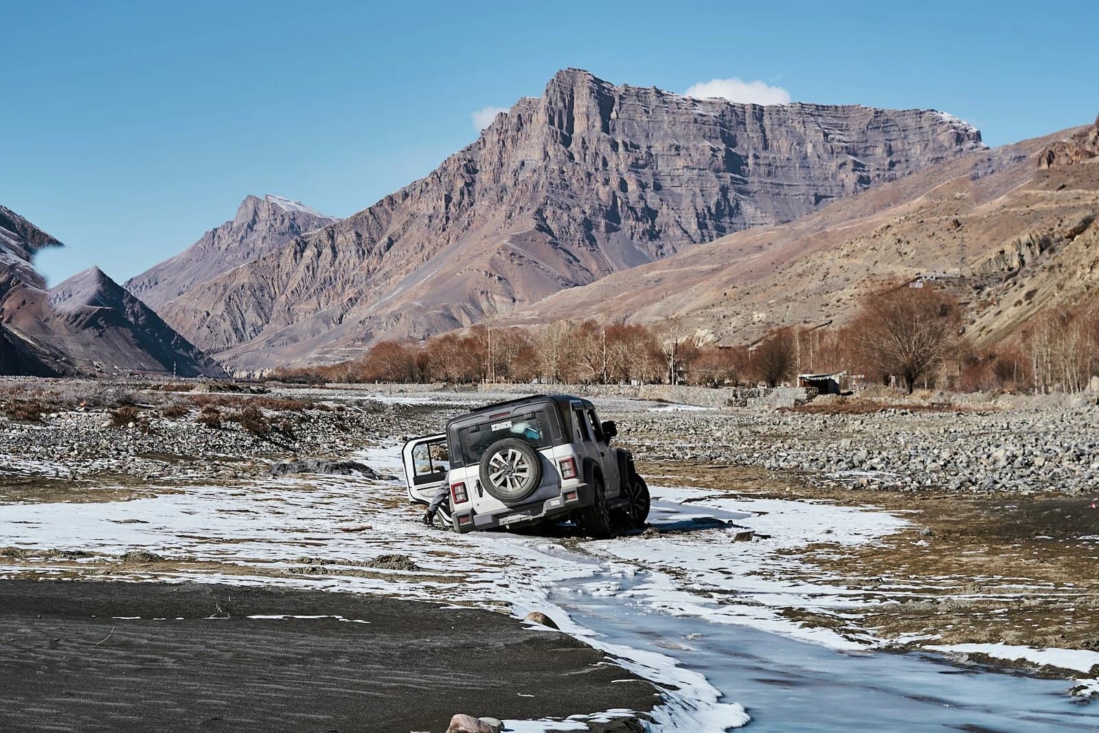 A 4×4 crossing a frozen river bed in the Himalaya — every kilometre of snow in your own car