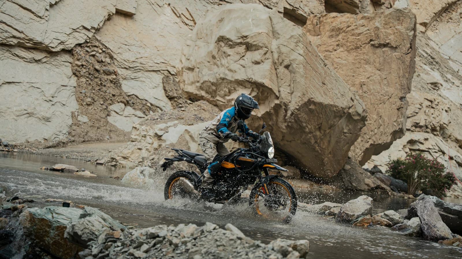 Motorcyclist crossing a stream on an adventure bike in Spiti Valley