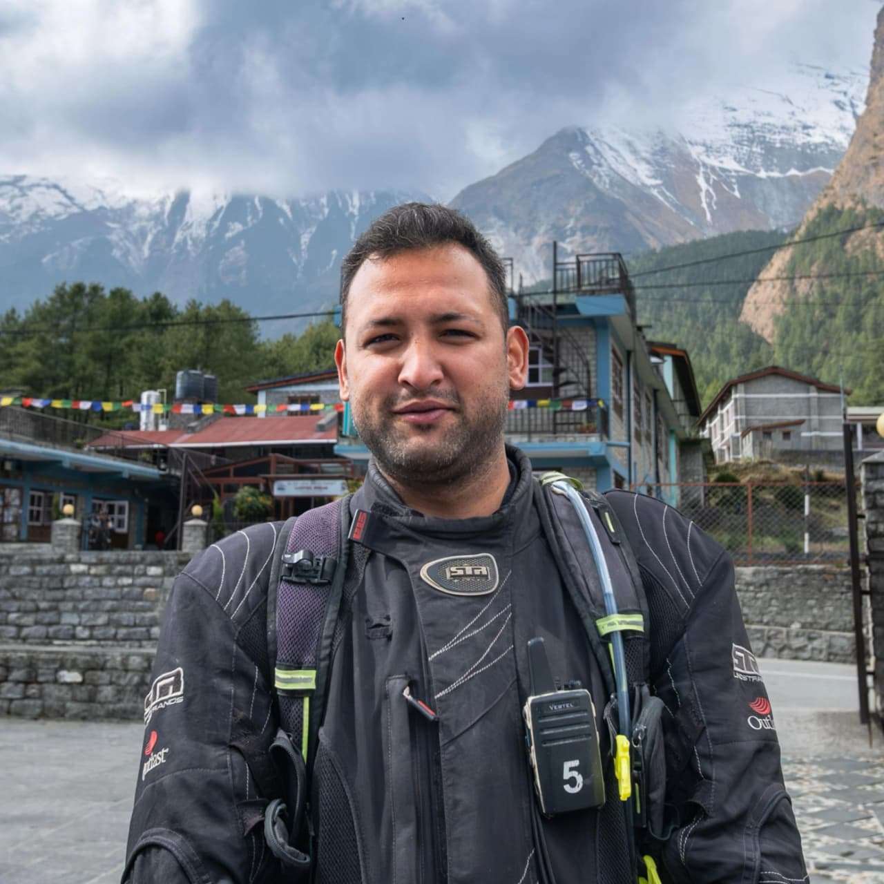 Ujjwal Thakur, Offhorizon Adventures team member, standing outdoors in mountain surroundings wearing adventure riding gear